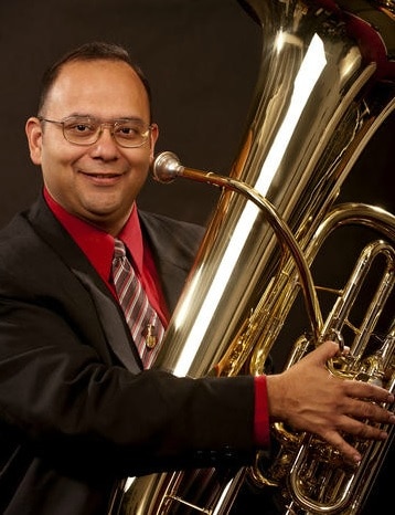 Headshot of Principal Tuba Player, Charlie Ortega with his Tuba